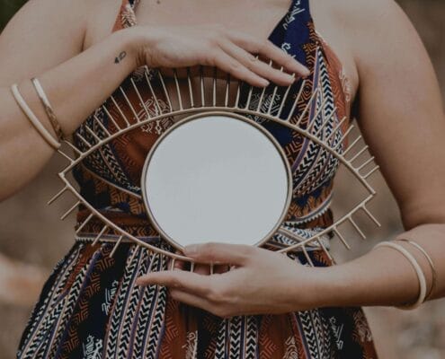 I woman holding a decorative sculpture of an eye. Cognitive Behavioral Therapy encourages insight.