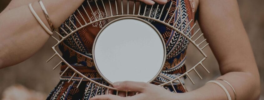 I woman holding a decorative sculpture of an eye. Cognitive Behavioral Therapy encourages insight.