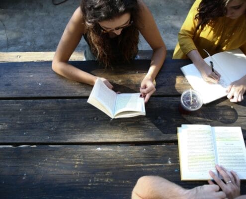 Learning disability can be debilitating academically and socially, especially for young people. A picnic table with 3 people studying.